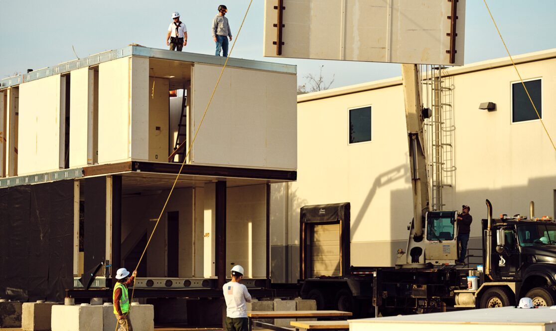 a modular home being assembled with cranes 