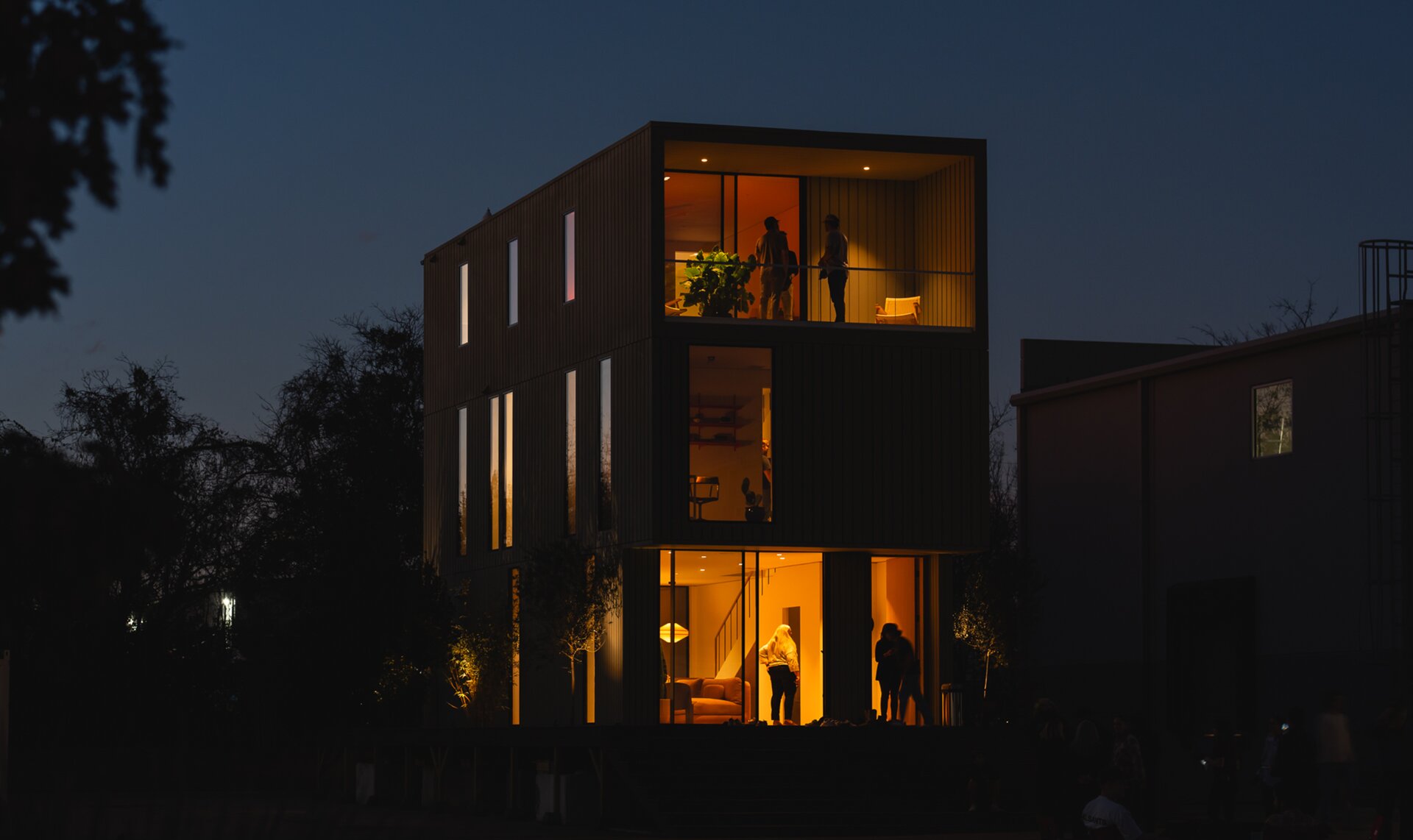 night view of a modular home with interior lighting shown through the windows