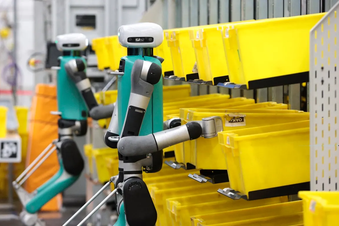 Bipedal robots in testing phase move containers during a mobile-manipulation demonstration at Amazon's "Delivering the Future" event.