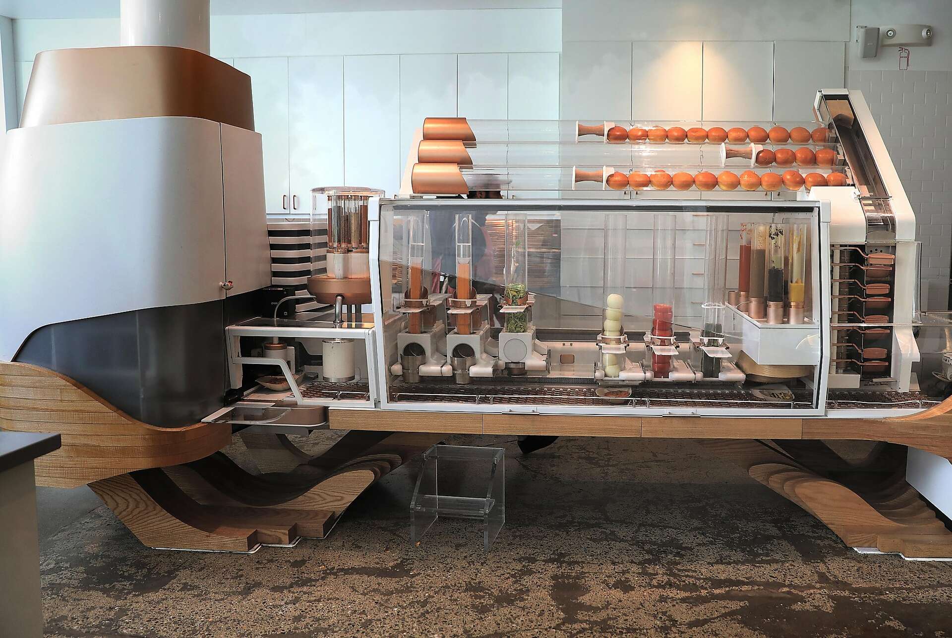 Creator using an assembly line to construct fresh burgers in San Francisco.