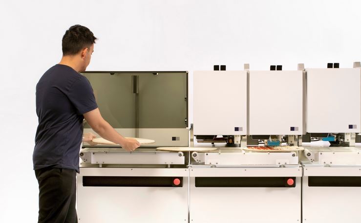 Picnic pizza maker uses an assembly line to add sauce, cheese, and toppings.