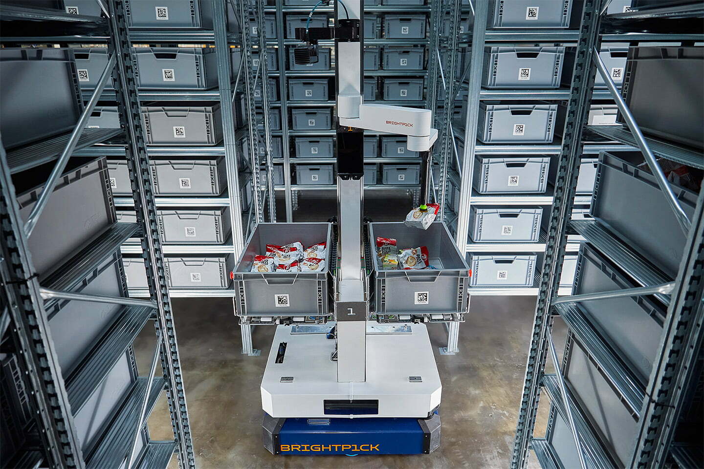 Brightpick Autopicker using its robotic arm to transfer an item from an inventory tote into an order tote.