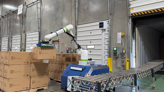 Pixmo uses robotic manipulation to stack and organize boxes onto pallets.