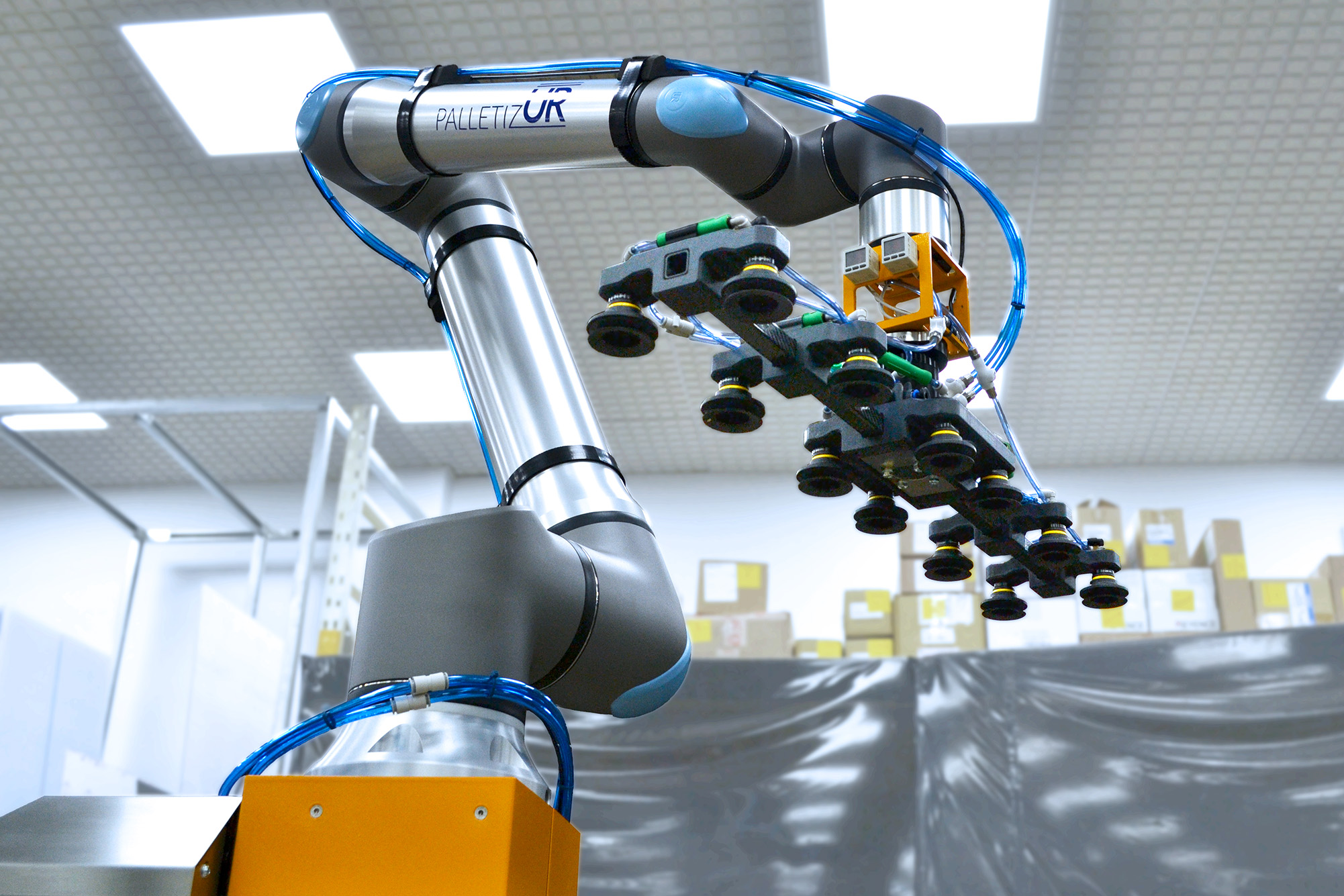 High-payload UR Series robotic arms equipped with palletizing end effectors for automated stacking and handling.