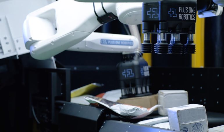 InductOne uses robotic arms and machine vision to transfer parcels onto automated sorting conveyors.