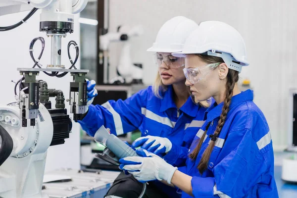 Experienced technician providing hands-on instruction to a student learning about robotics and industrial automation.